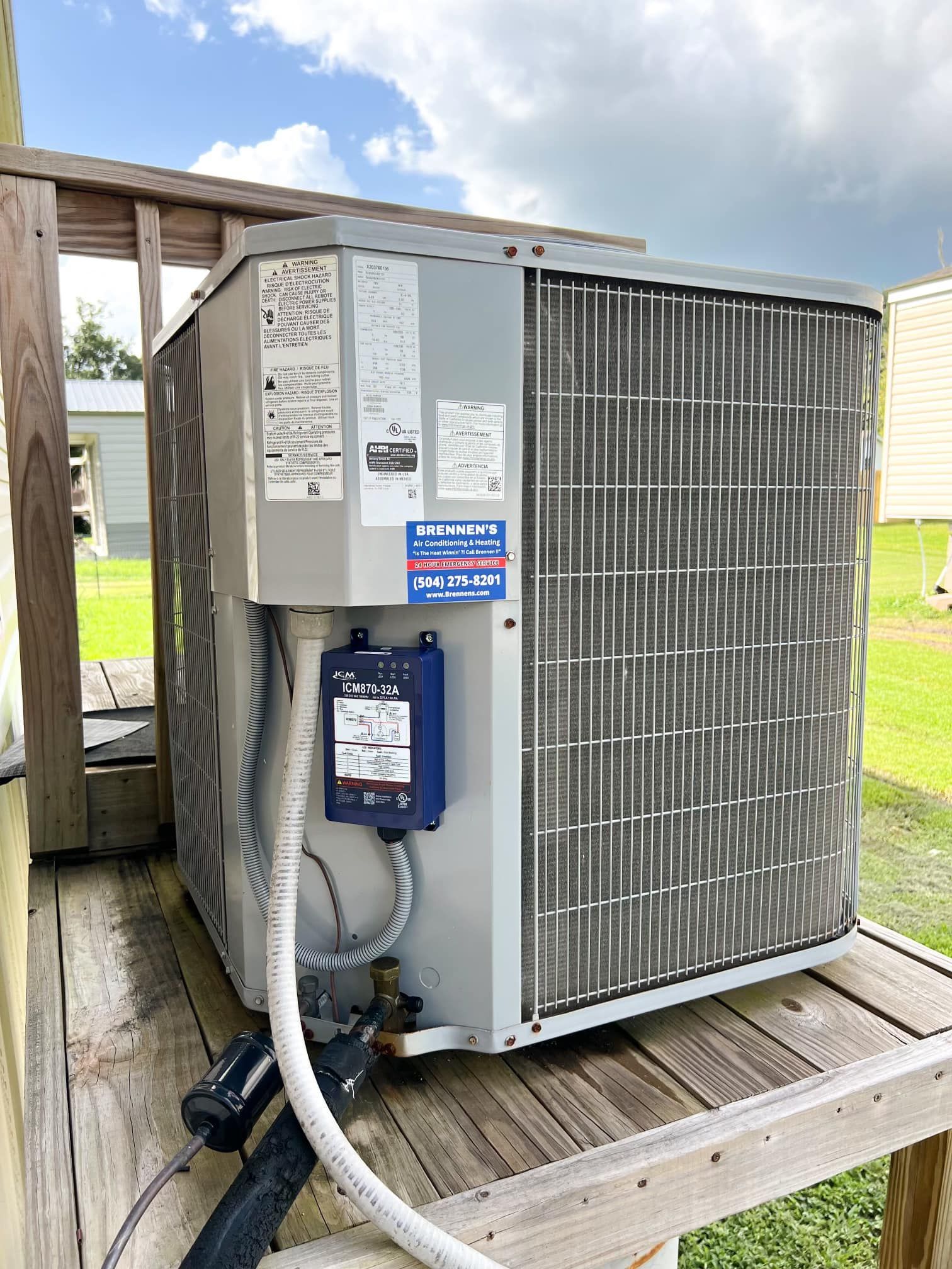 A large air conditioner is sitting on top of a wooden deck.