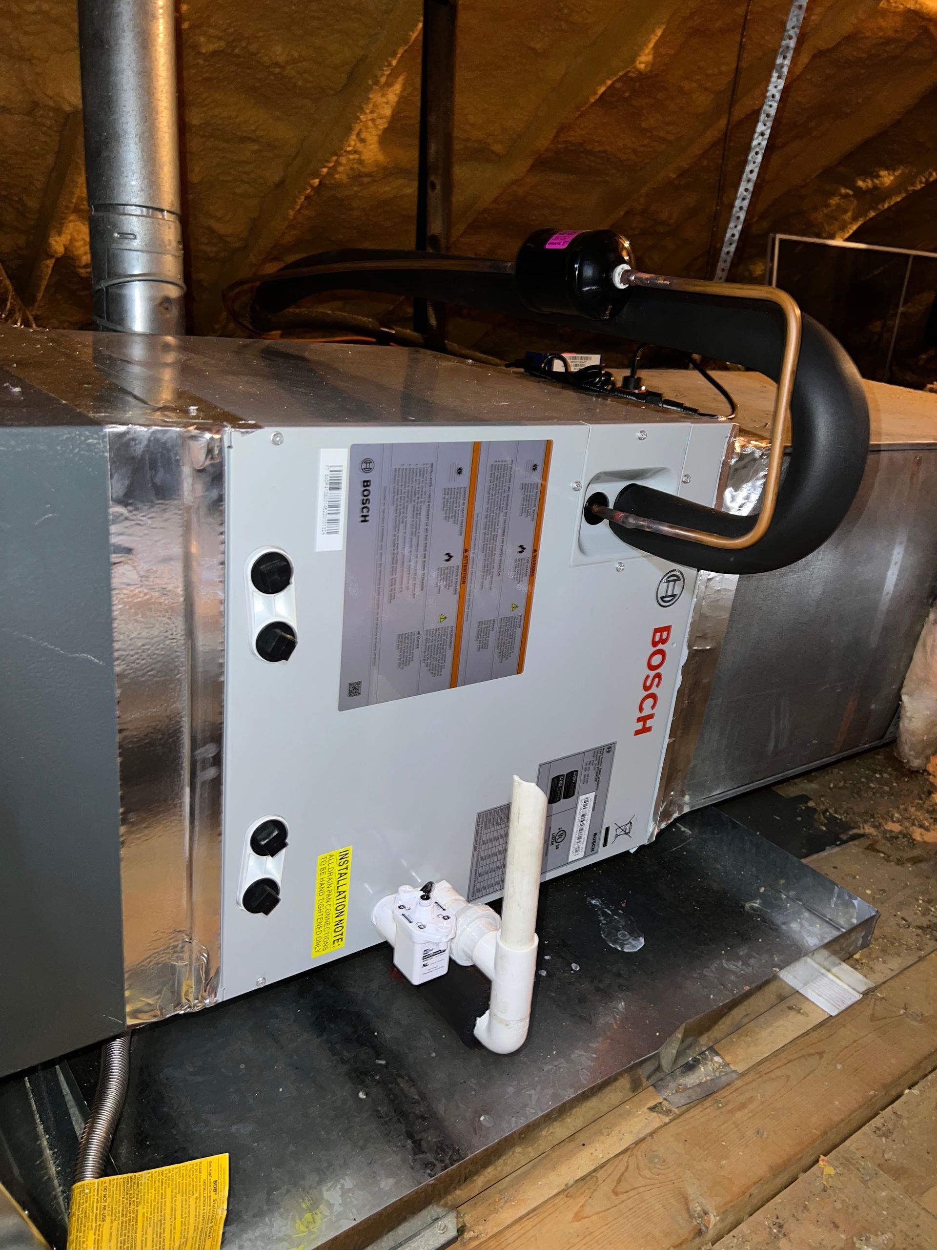 An air conditioner is sitting in the attic of a house.