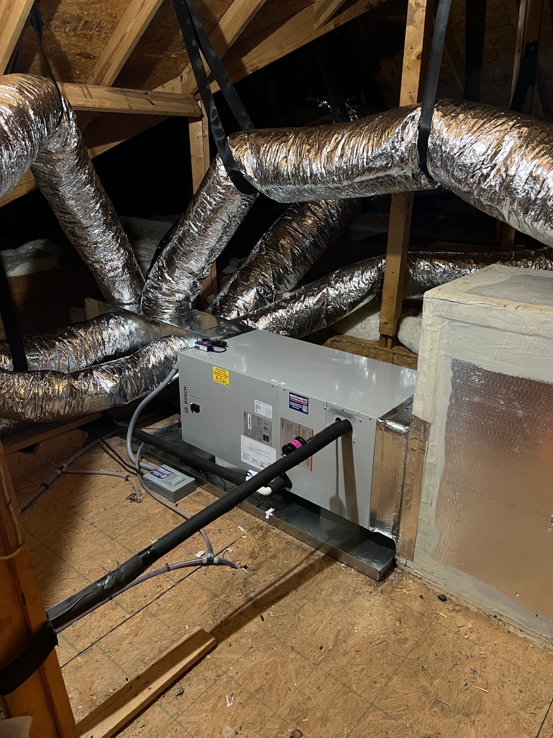 A bunch of ducts are hanging from the ceiling of a room.