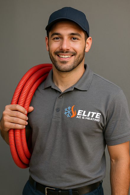 A man in a gray shirt is holding a red hose over his shoulder.