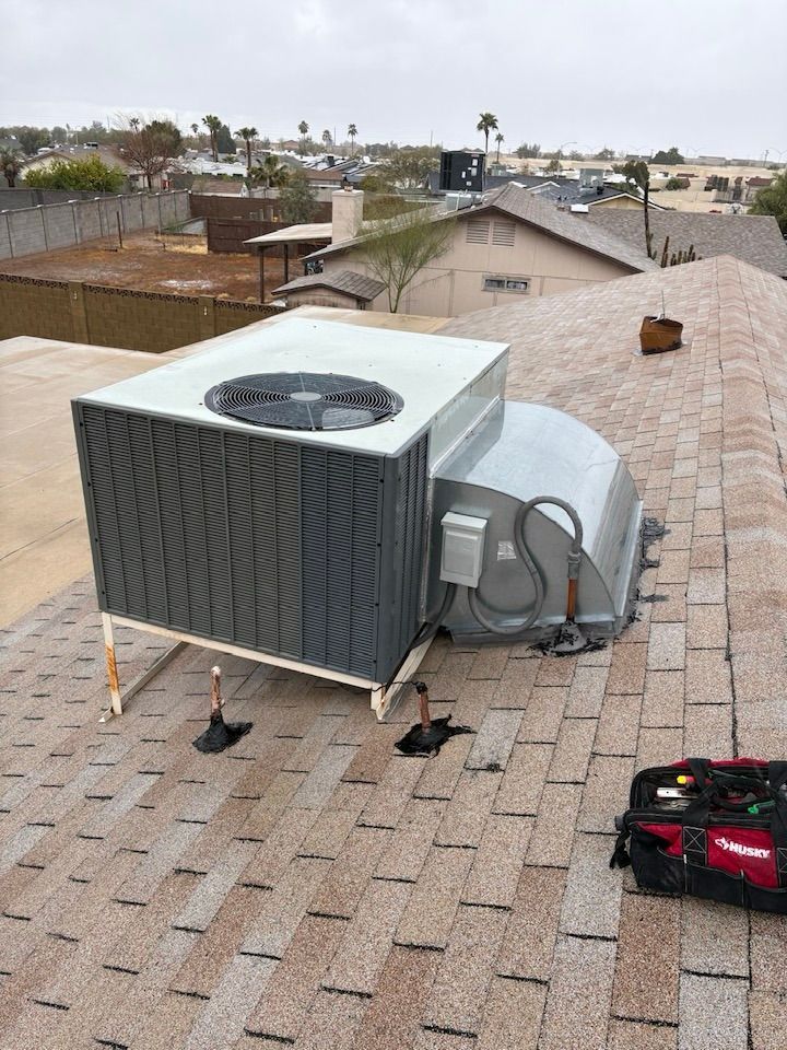 A large air conditioner is sitting on top of a roof.