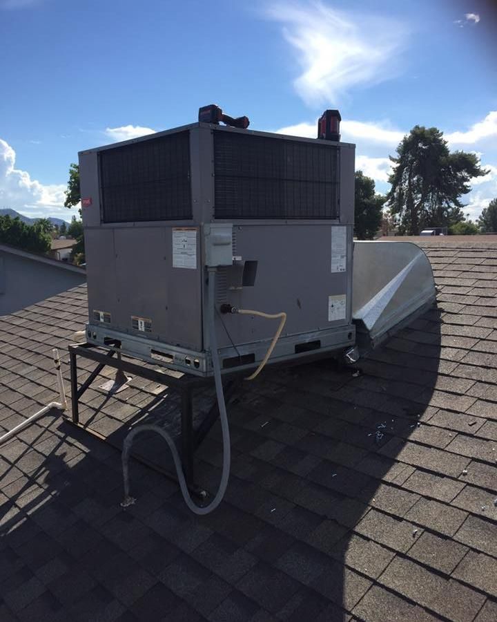 A large air conditioner is sitting on top of a roof.