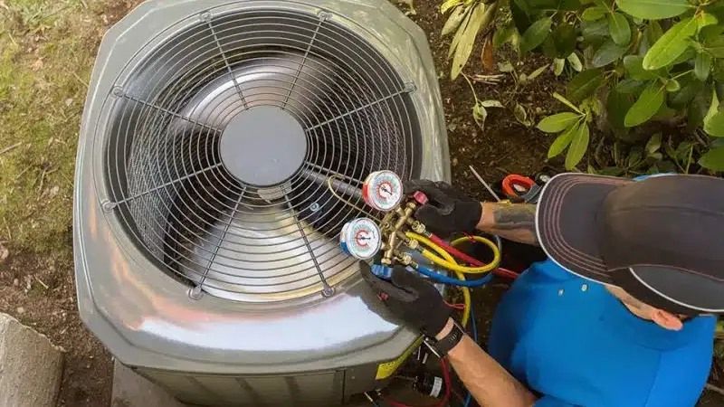 A man is working on an air conditioner outside.