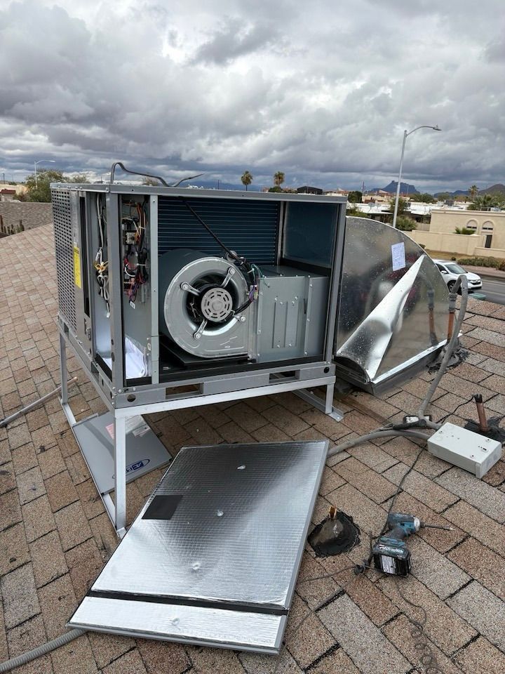 A broken air conditioner is sitting on top of a brick roof.