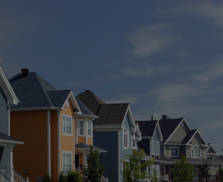 A row of houses with a blue sky in the background