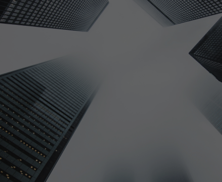 Looking up at a group of tall buildings on a gray background.