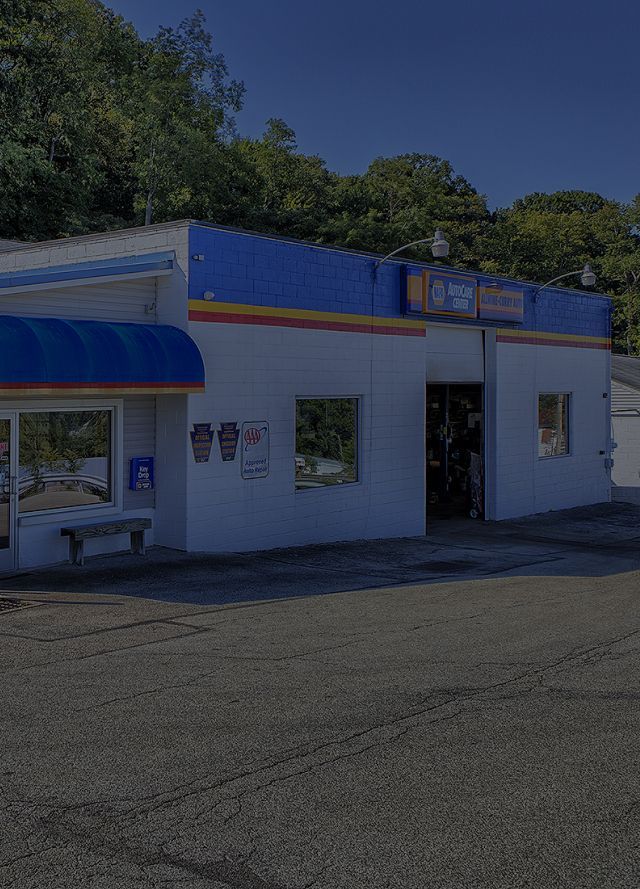 Small white roadside store with blue trim and a shaded awning under a clear sky | Allwine Curry Inc