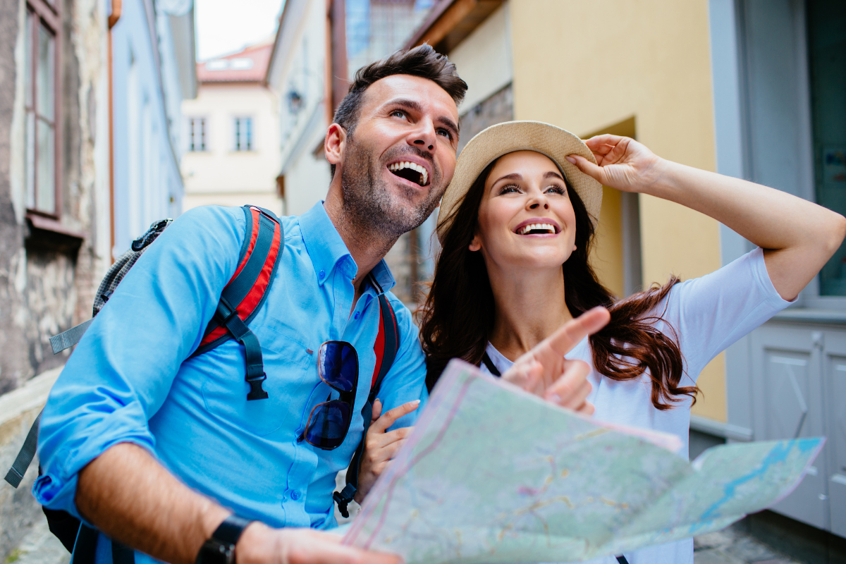 a man and a woman are looking at a map .