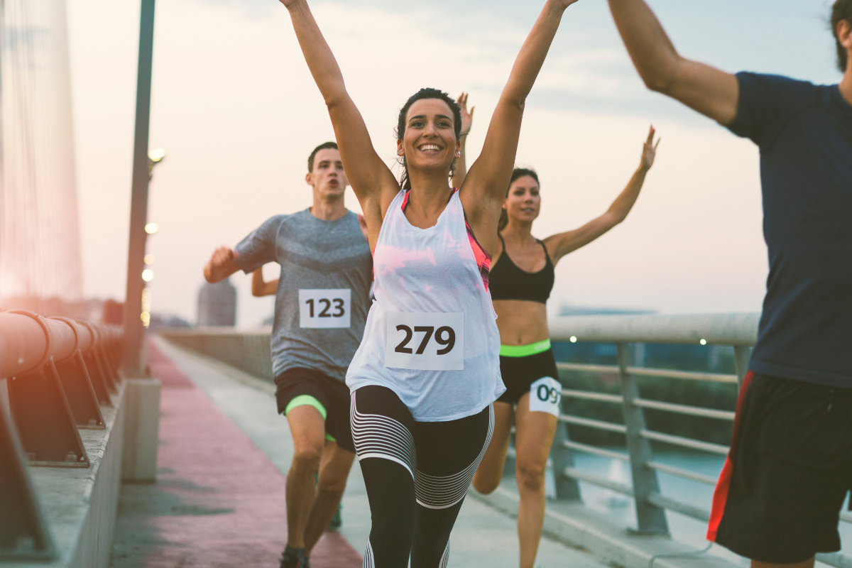 a group of people are running a race on a bridge .