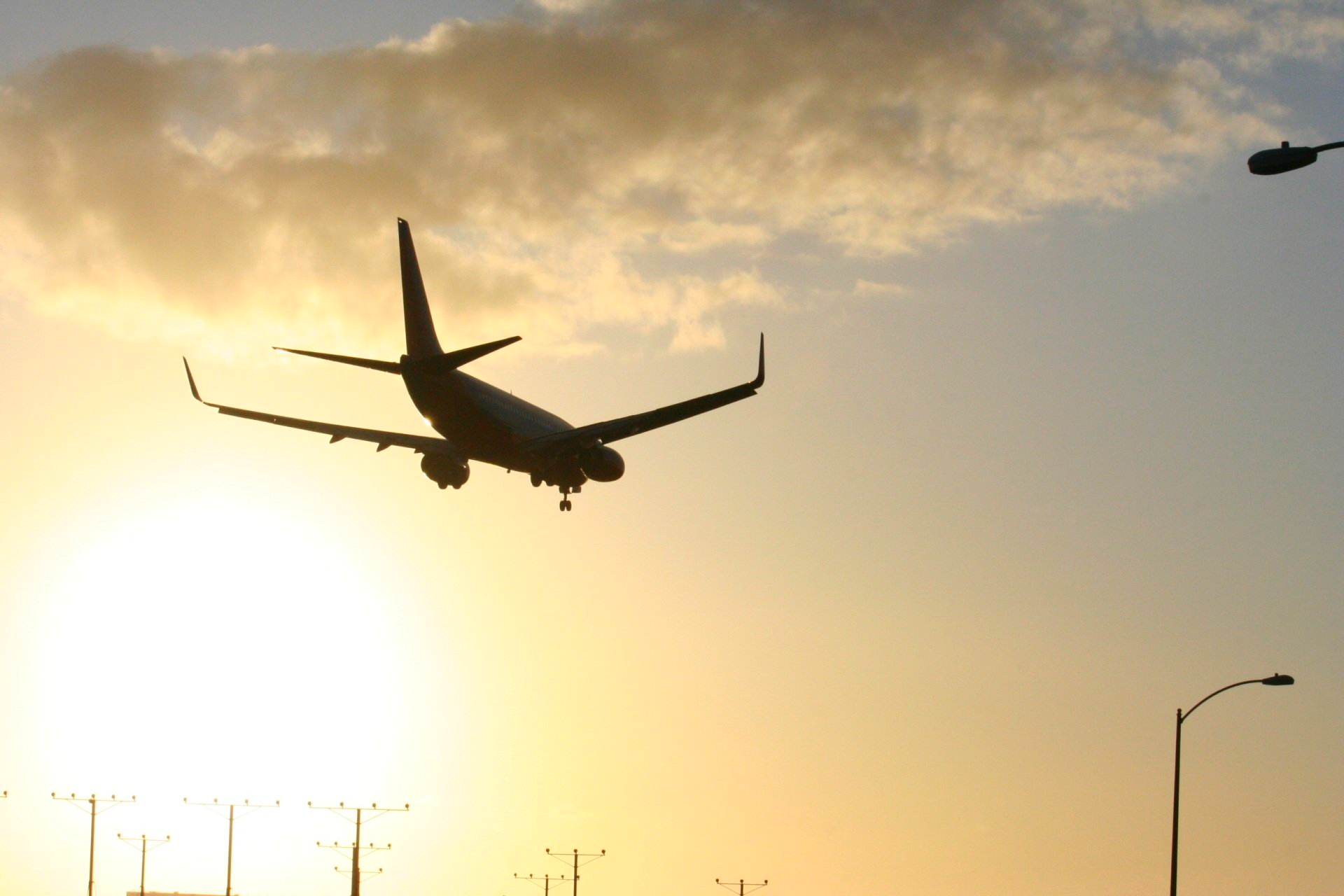 an airplane is flying in the sky at sunset