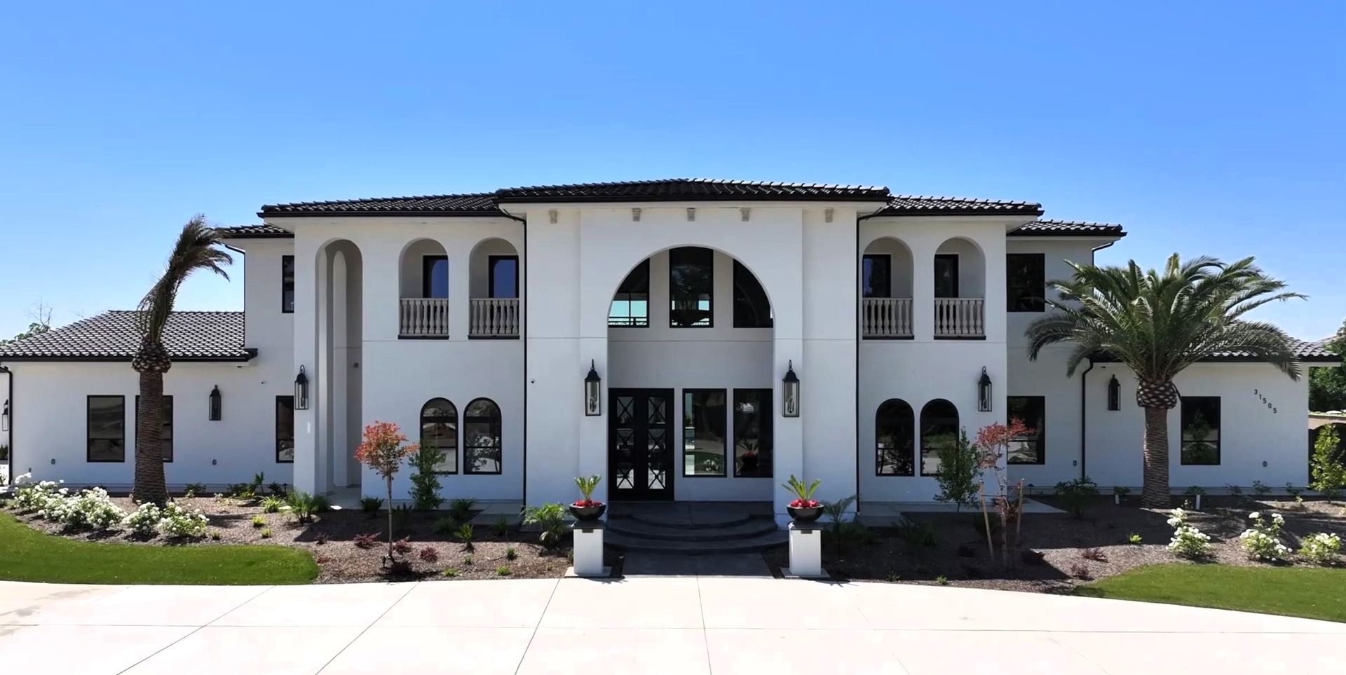 A large white house with palm trees in front of it modern Mediterranean style 