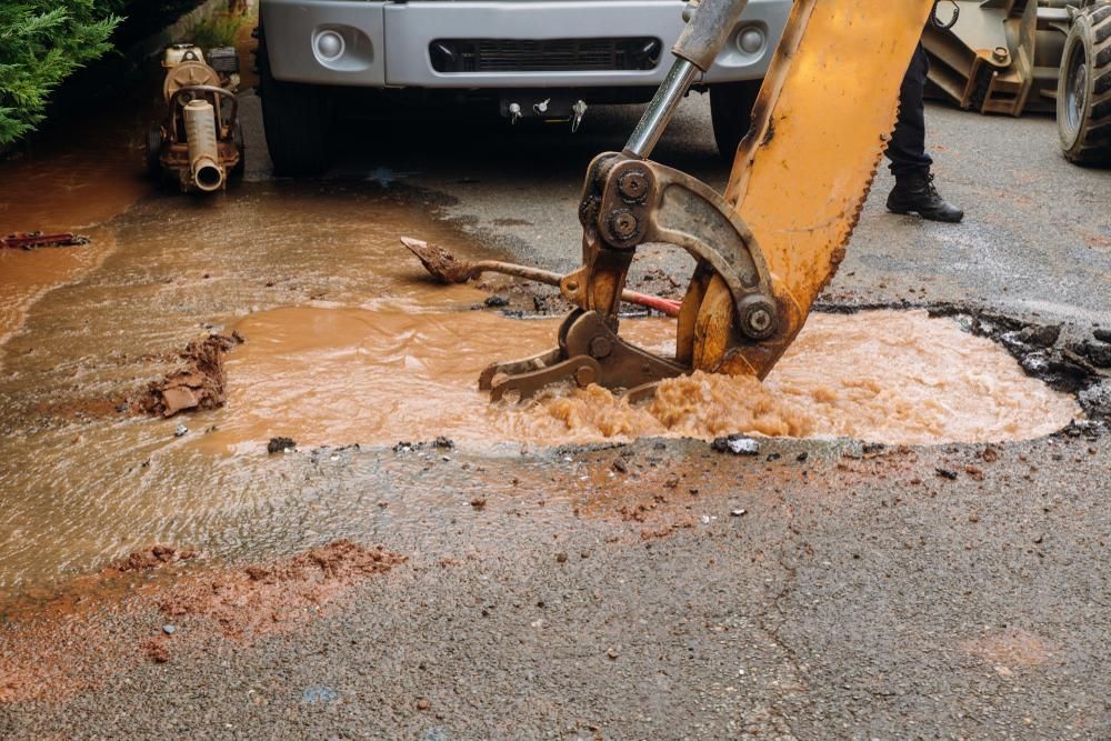 A Man is Using an Excavator to Dig a Hole in the Ground — Gold Coast Leak Detection in Mudgeeraba, QLD