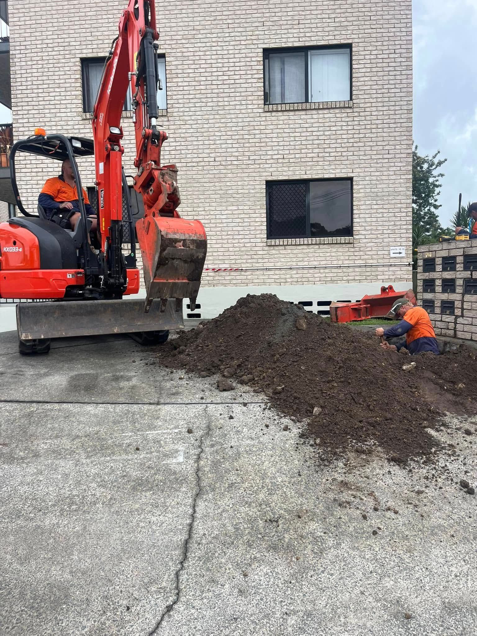 A Small Excavator and Construction Worker — Gold Coast Leak Detection in Worongary, QLD