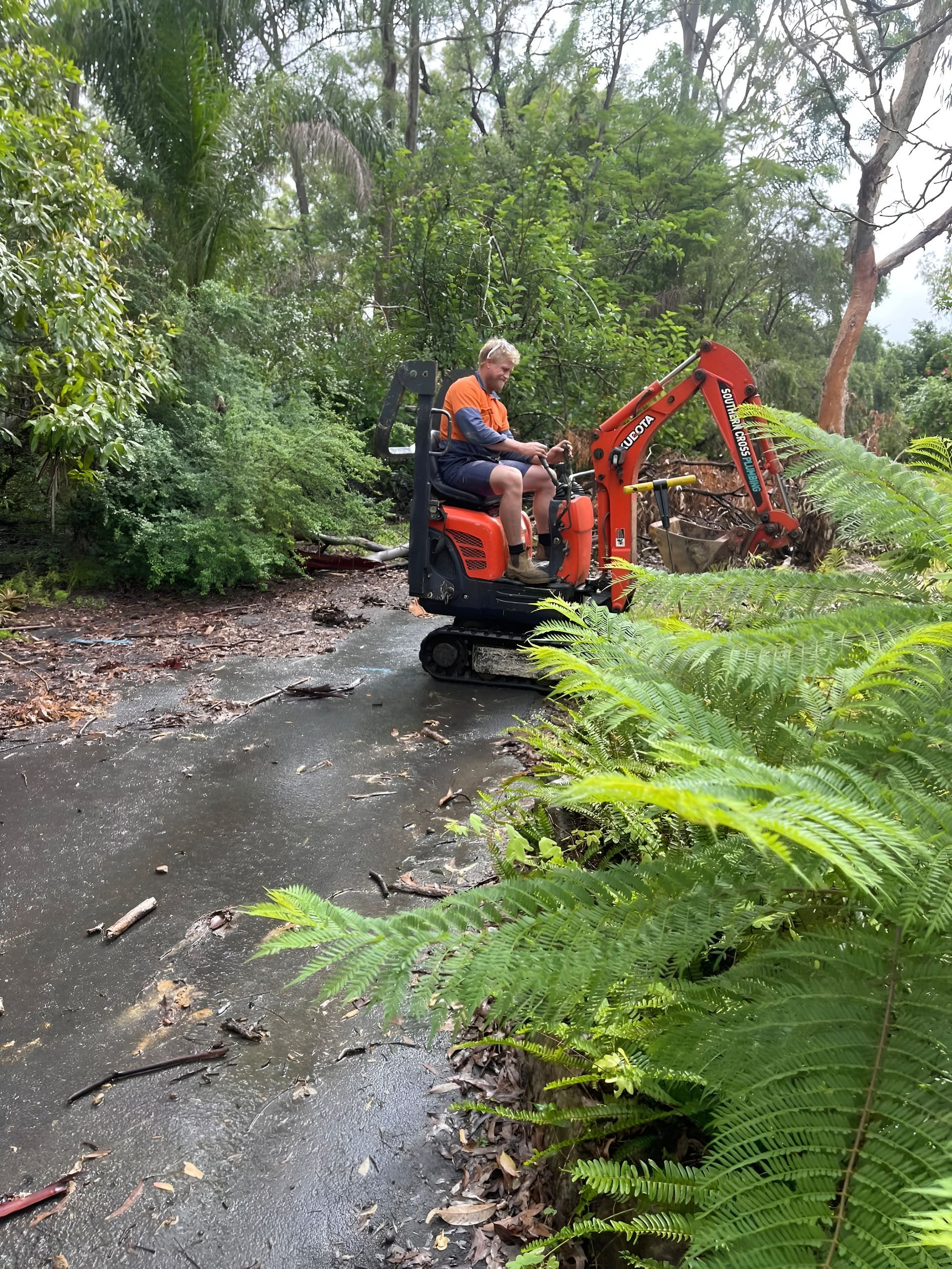Man Operating a Small Orange Excavator — Gold Coast Leak Detection in Tallebudgera, QLD
