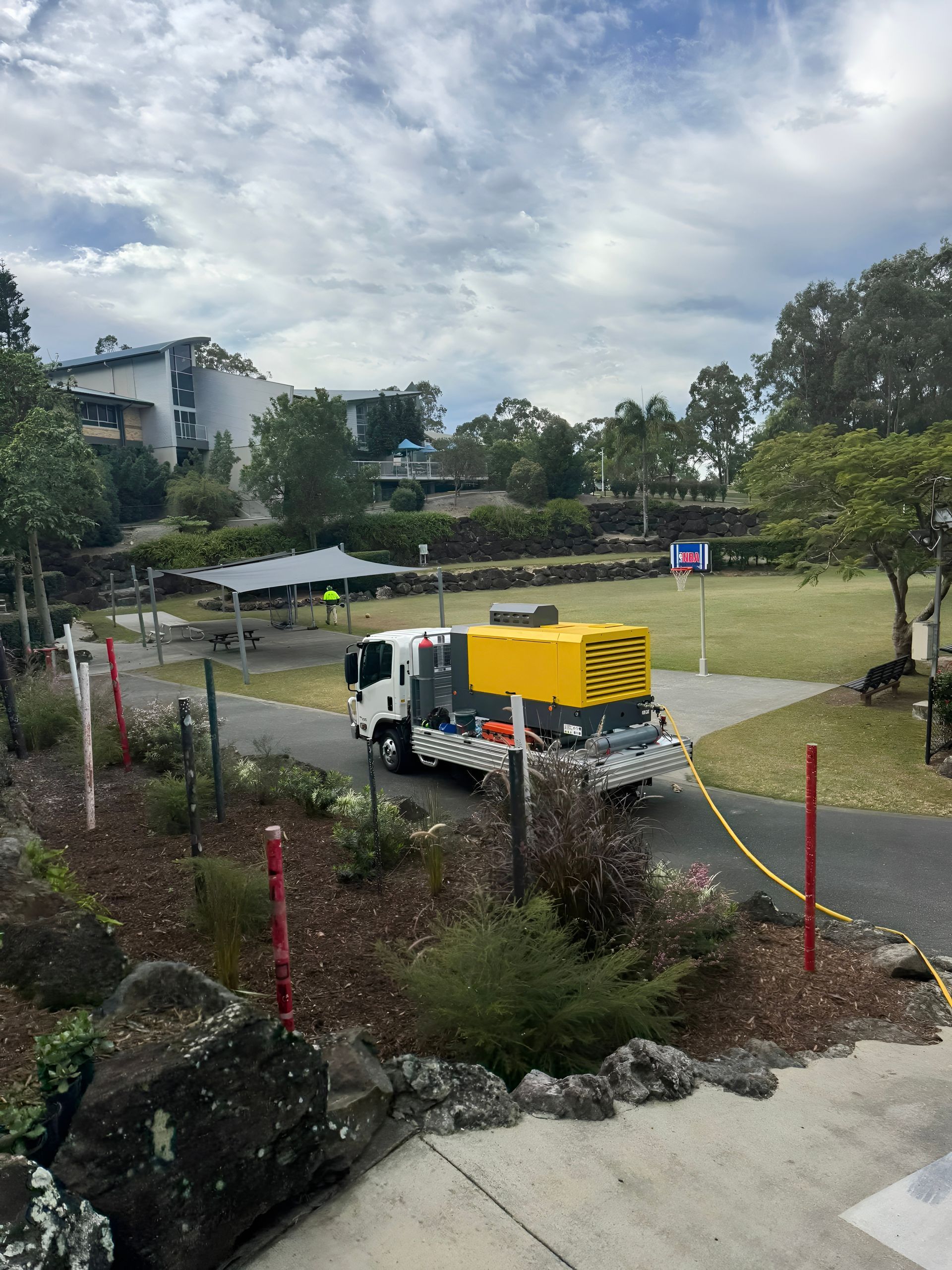 A Truck With a Yellow Generator on a Grassy Area — Gold Coast Leak Detection in Worongary, QLD