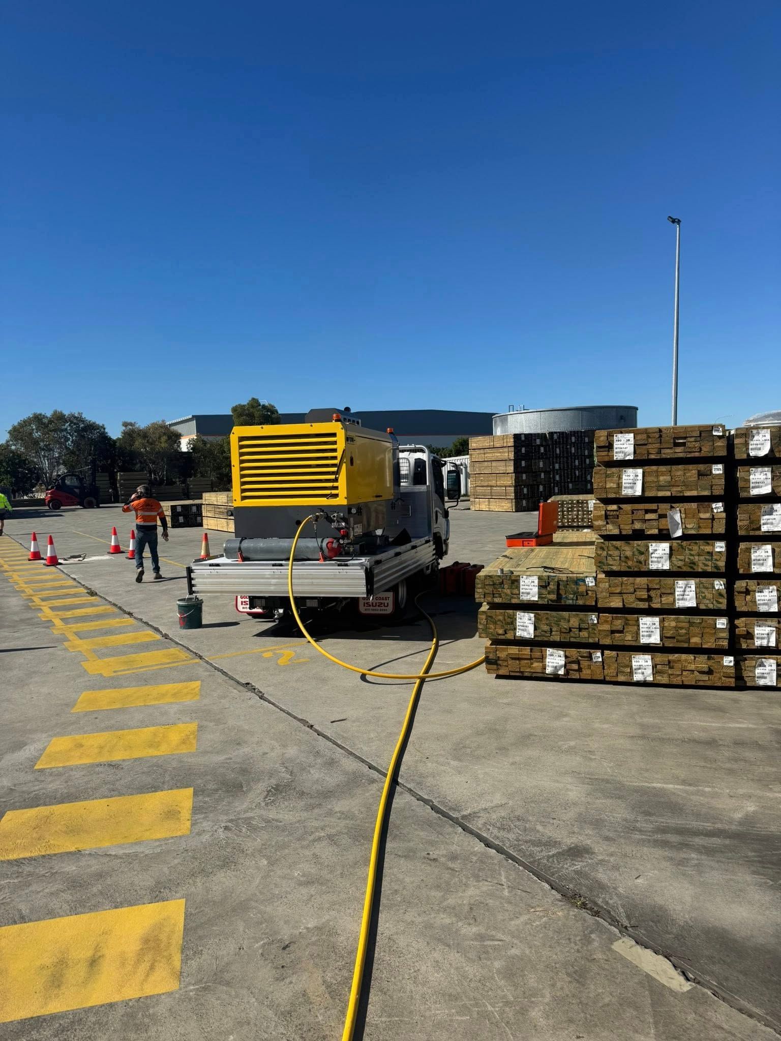 A Yellow Generator on a Truck, Next to Stacked Lumber — Gold Coast Leak Detection in Bonogin, QLD