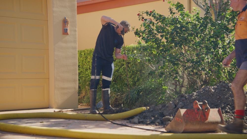 A Man is Working on a Security Camera on a Bridge — Gold Coast Leak Detection in Mudgeeraba, QLD