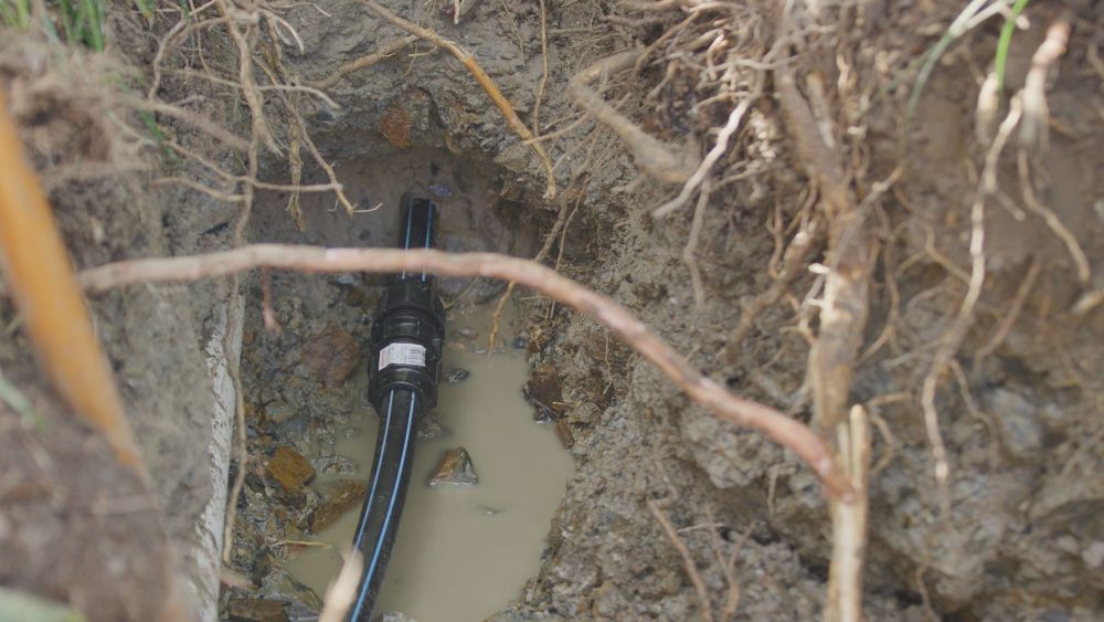 A Sprinkler is Spraying Water on a Muddy Field — Gold Coast Leak Detection in Mudgeeraba, QLD