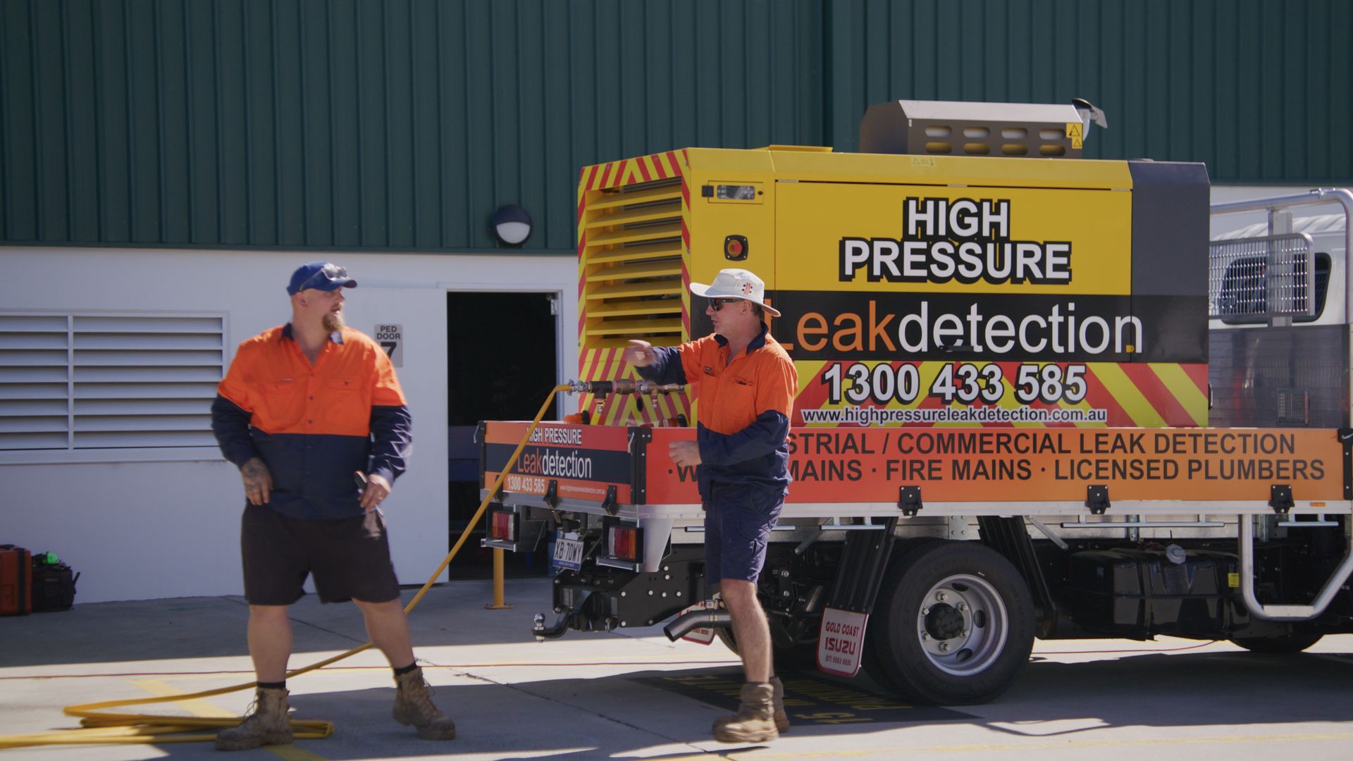 Two Men In Work Clothes By A Truck Labeled