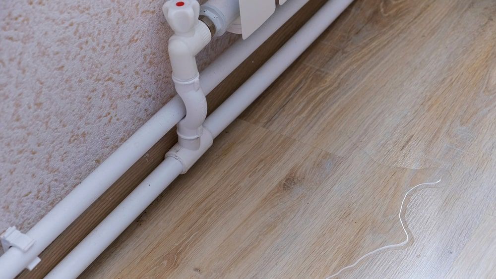 A Pipe Is Connected To A Radiator On A Wooden Floor — Gold Coast Leak Detection In Mudgeeraba, QLD