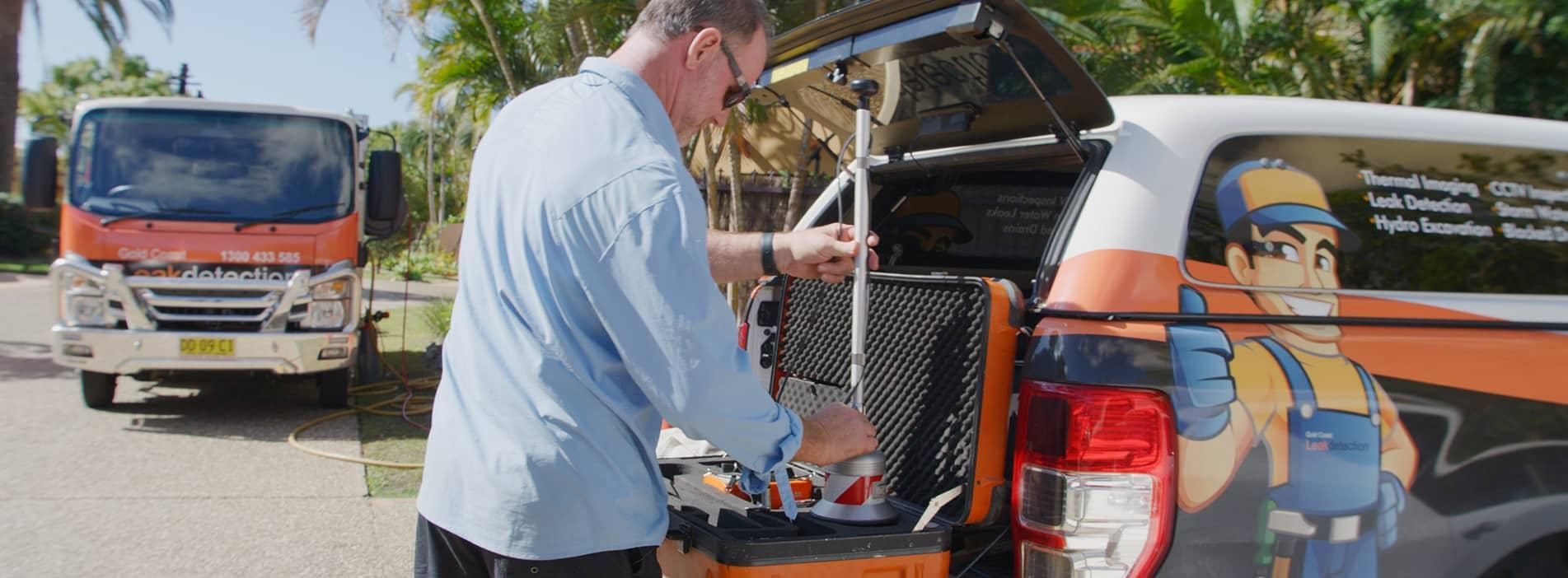 A Man Is Loading Tools Into The Back Of A Truck — Gold Coast Leak Detection In Mudgeeraba, QLD