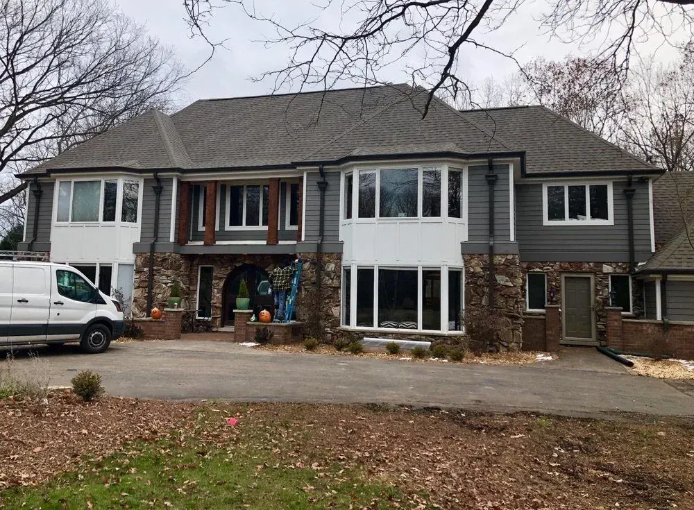 A large house with a van parked in front of it.