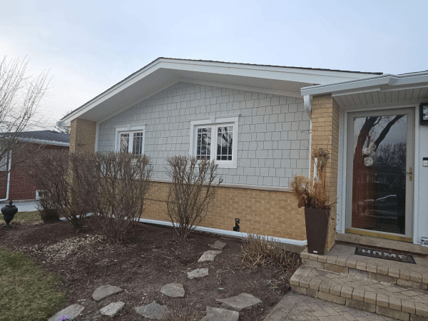 A house with a white siding and a red door