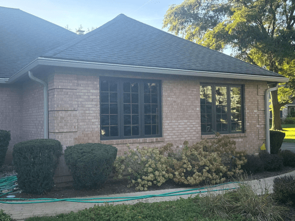 A brick house with a black roof and black windows