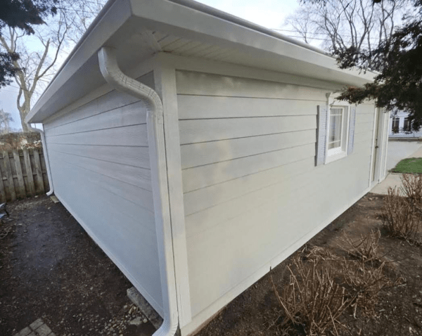 A white house with a gutter on the side of it
