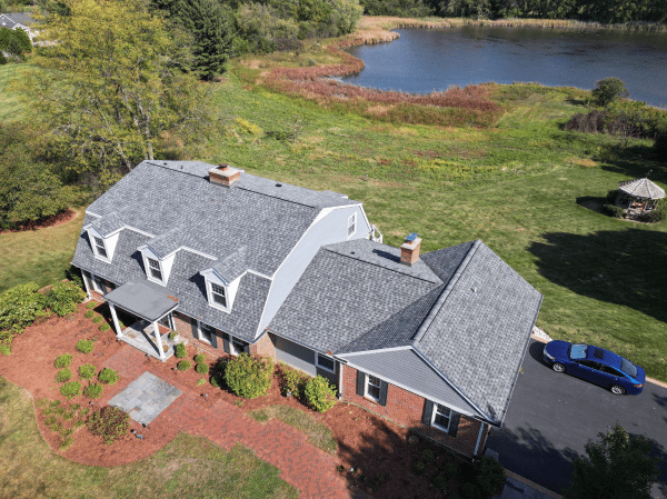An aerial view of a house with a lake in the background.