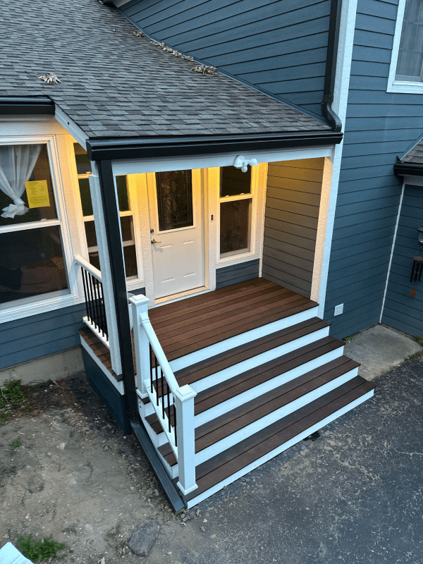 A house with a porch and stairs on the side of it.