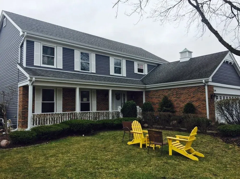 A house with yellow chairs in front of it