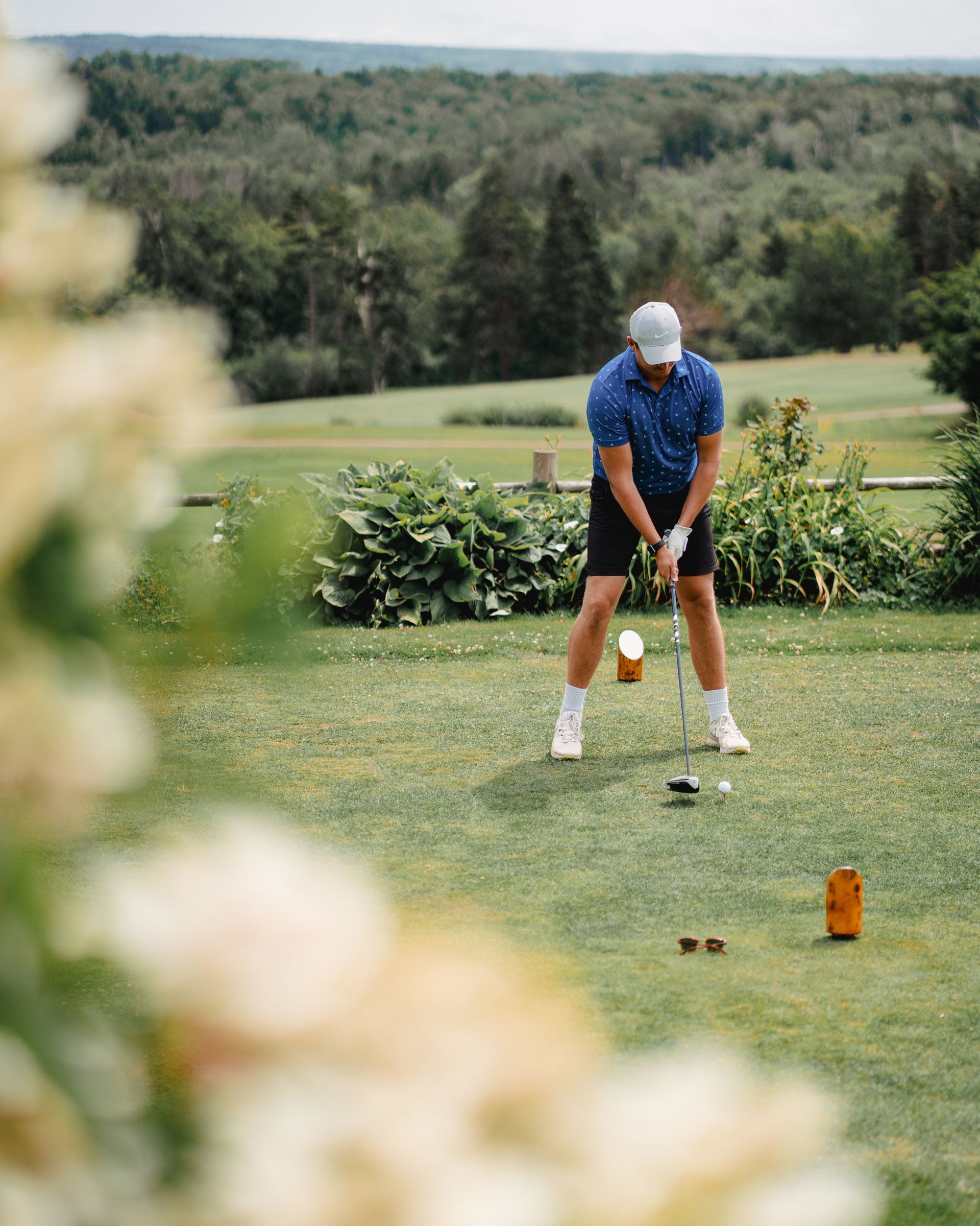 A man is swinging a golf club on a golf course