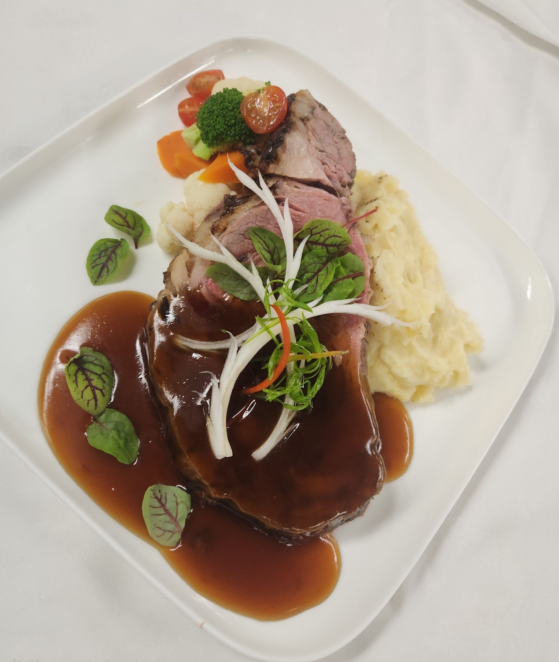 A plate of food with a bottle of wine in the background