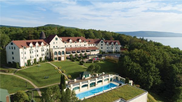 An aerial view of a large building with a swimming pool in front of it