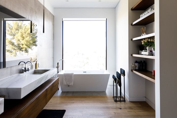 A bathroom is being remodeled with a toilet and a drill on the floor.