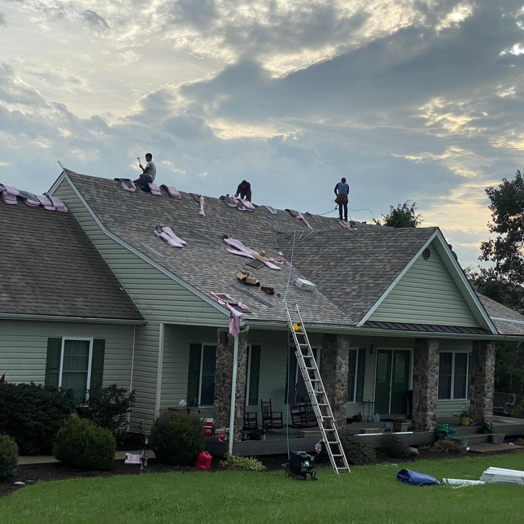 Two men are working on the roof of a house.