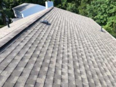Two men are working on the roof of a house.