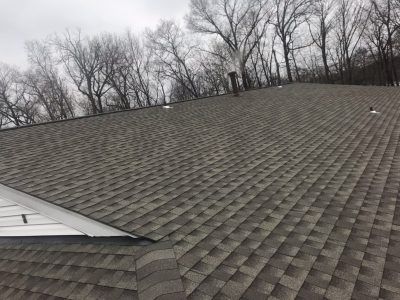 Two men are working on the roof of a house.