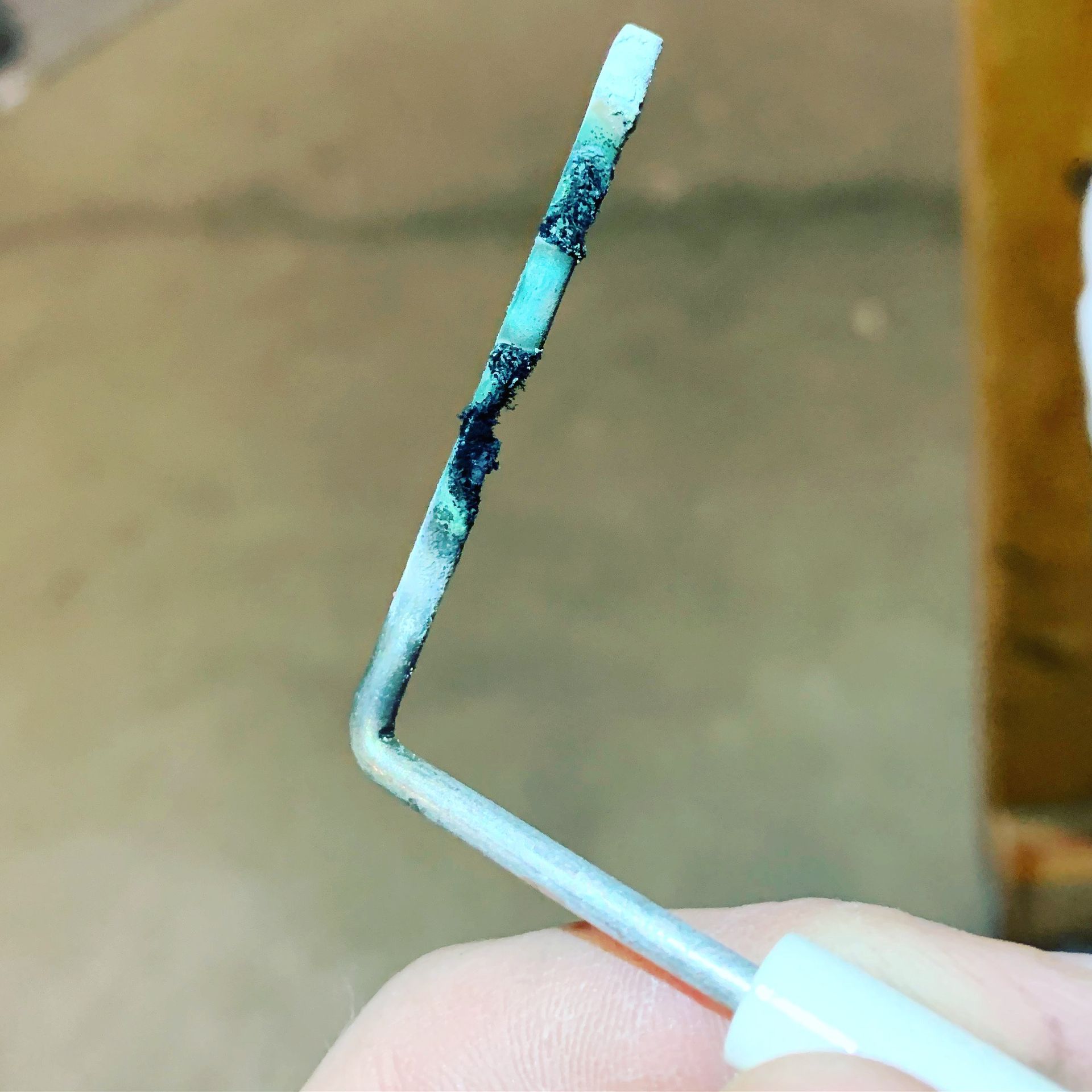 A close up of a person holding a piece of wire