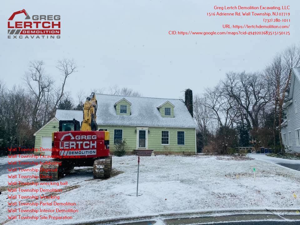 A lertch excavator is in front of a house in the snow