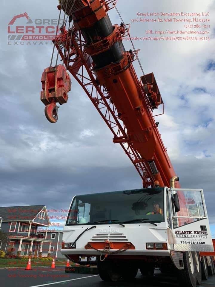 A large orange and white crane is parked on the side of the road