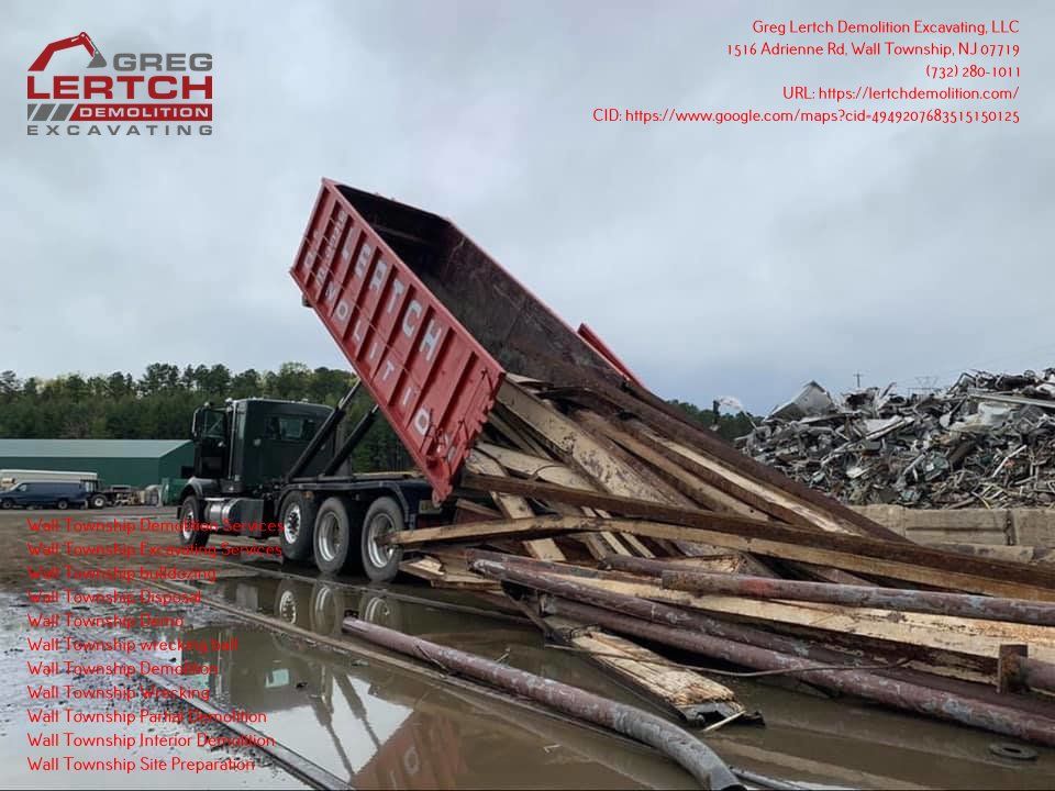 A dump truck is dumping wood into a pile of trash