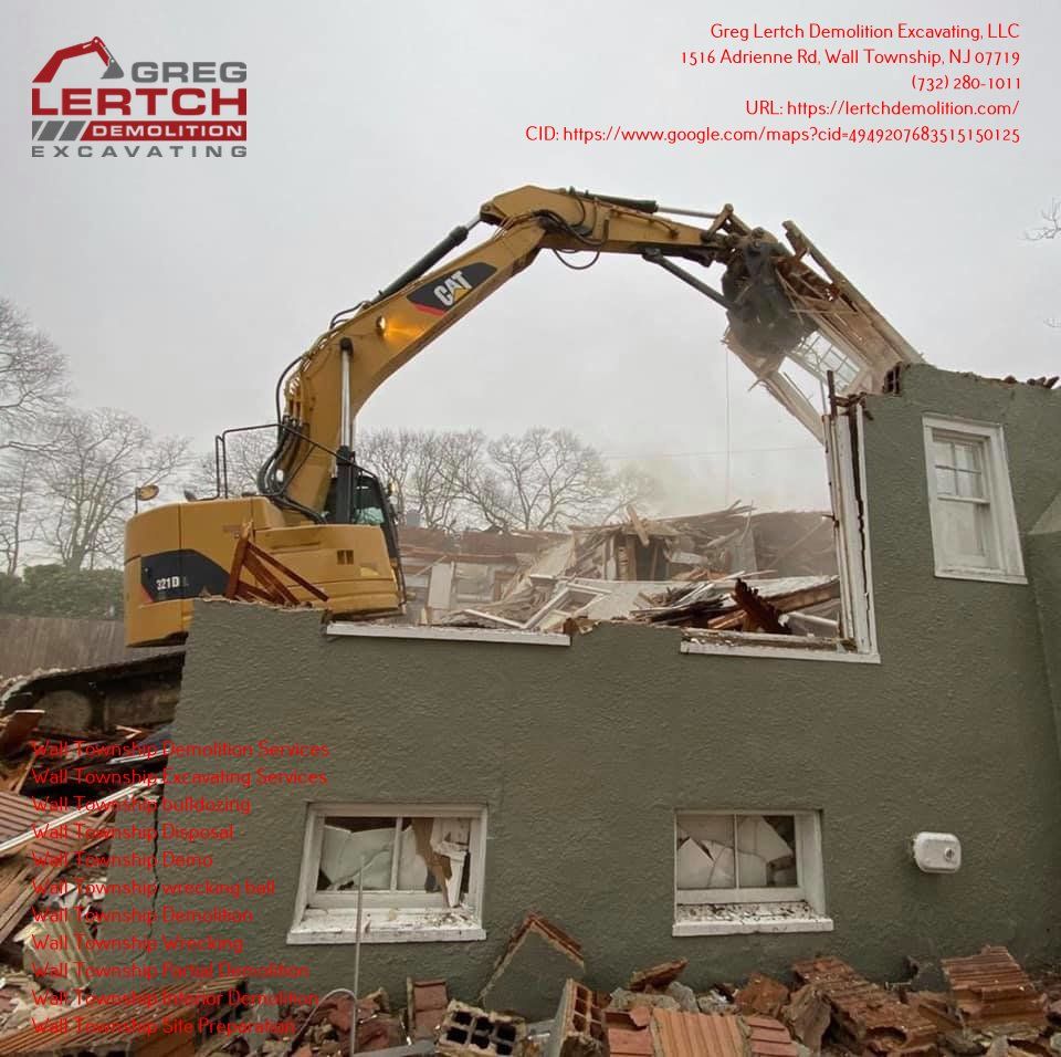A cat excavator is demolishing a house in a photo from greg lertch