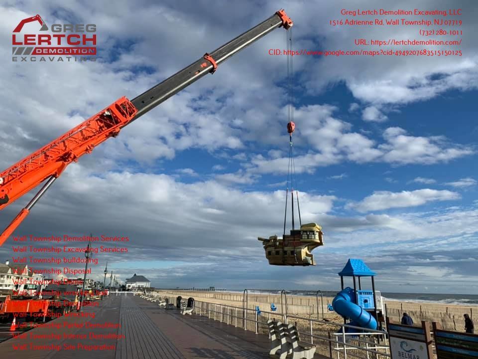 A crane is lifting a playground structure on a beach