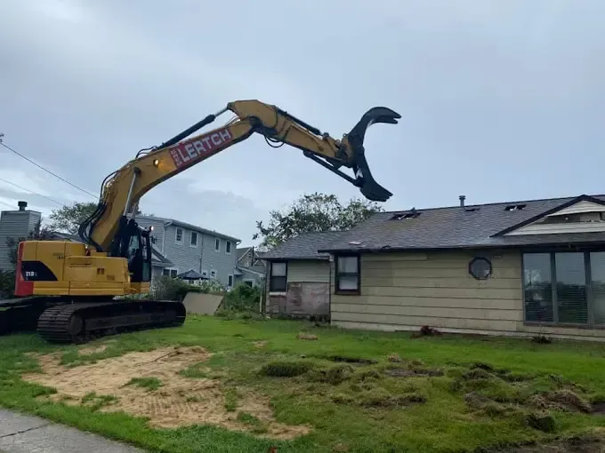 Excavator about to demolish a small house