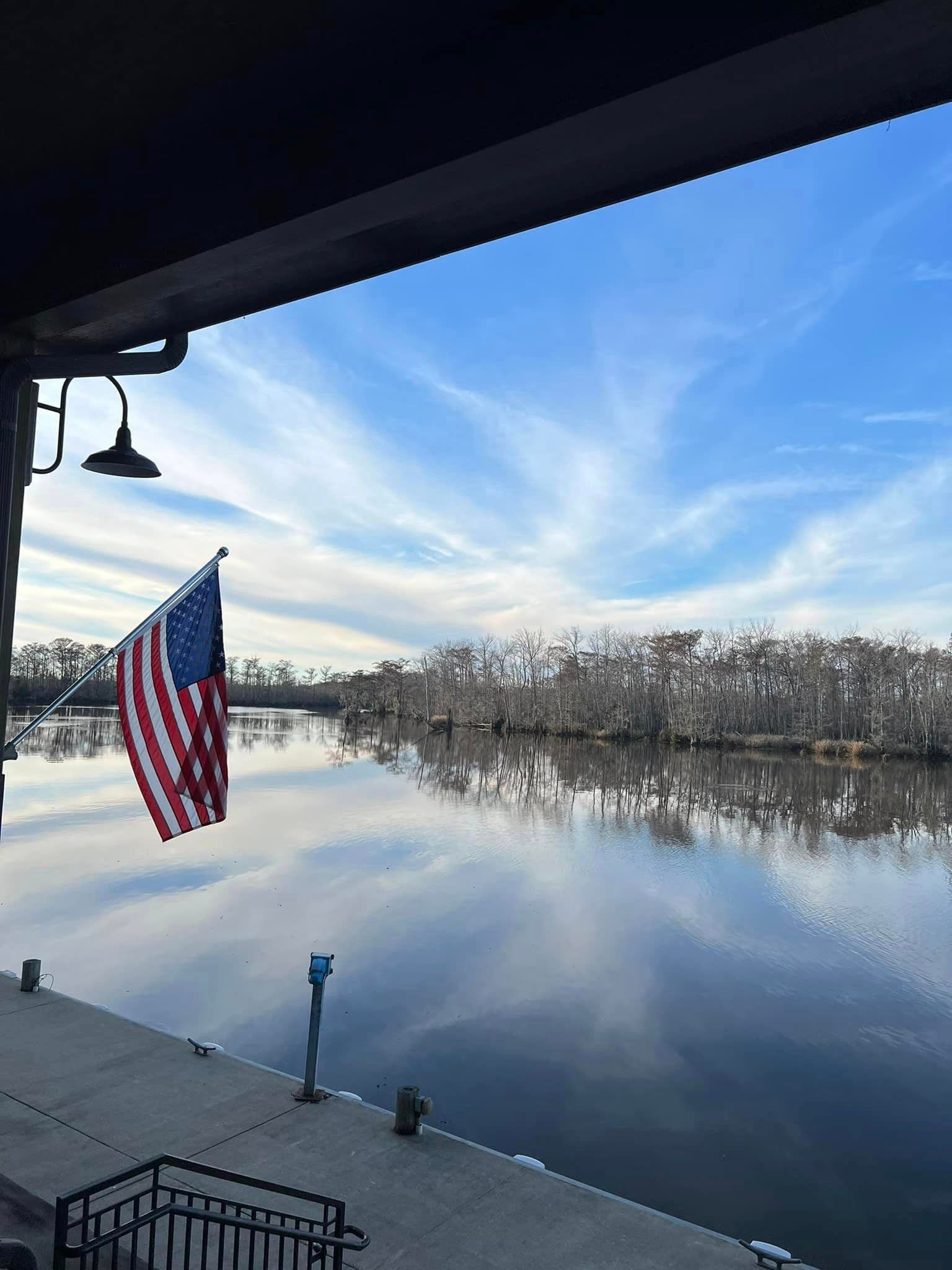 An american flag is flying over a body of water.