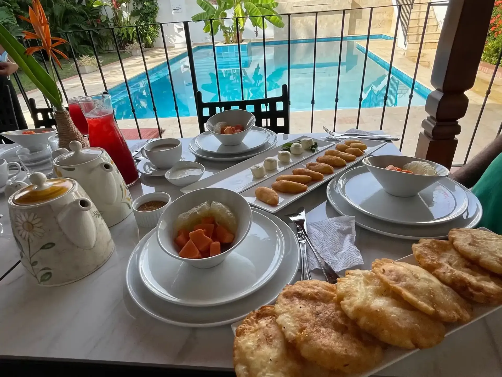 Desayuno servido frente a la piscina en hotel boutique Mompox, experiencia gastronómica de Karakalí para empezar el día con calma.