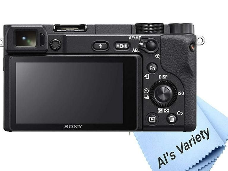 A person holds a black Canon DSLR camera up to their face against a plain red background.