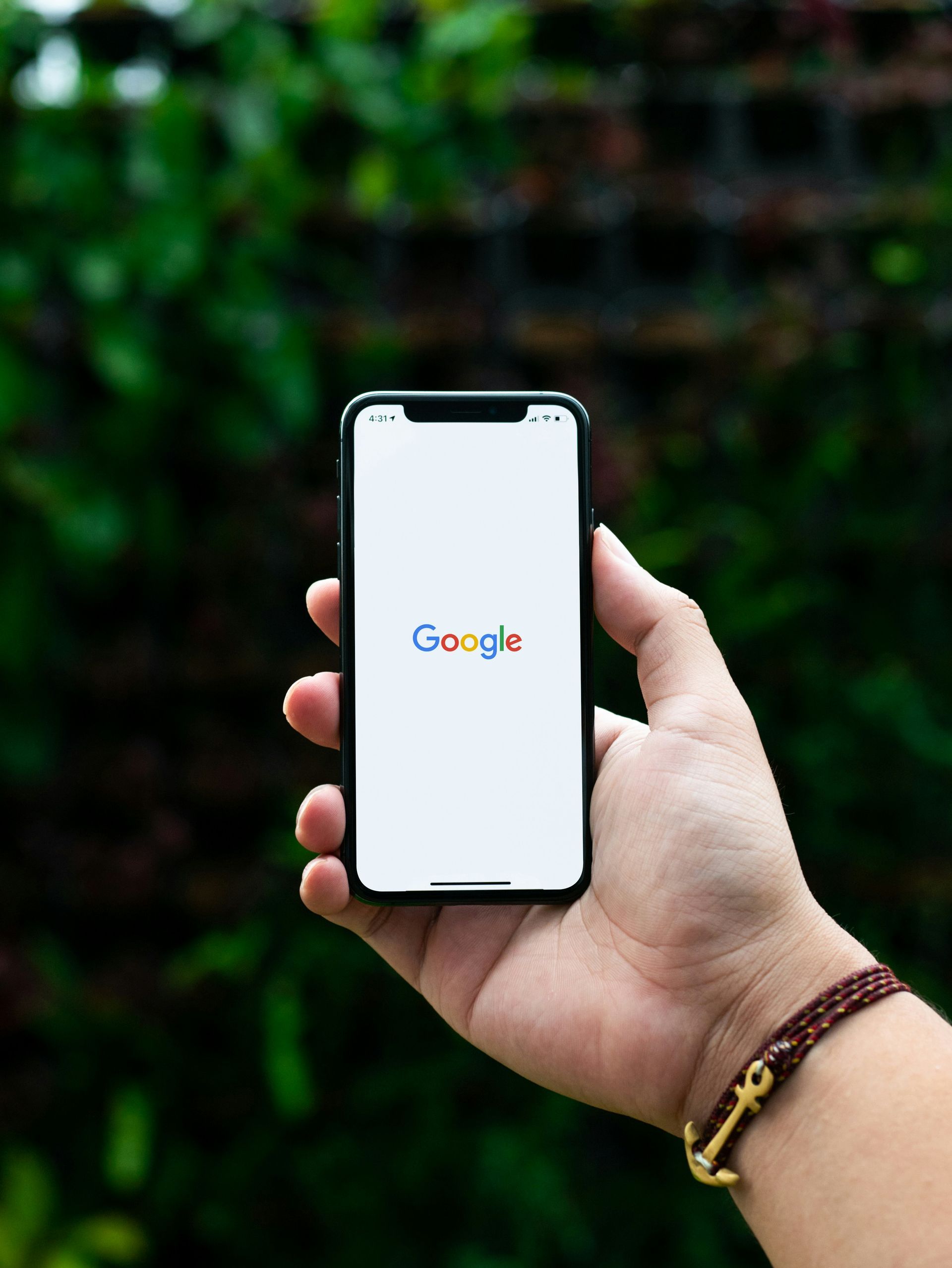 A person is holding a cell phone with google on the screen